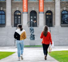 Students walking together in the quad with view of Carnegie Library